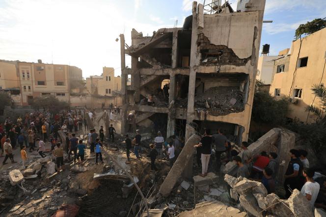 Palestinians search through the rubble of a building after an Israeli strike in Khan Yunis in the southern Gaza Strip on October 17, 2023. 
