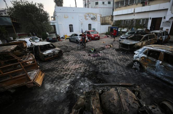 Palestinians look at the site of the explosion at al-Ahli hospital in Gaza City, on October 18, 2023.