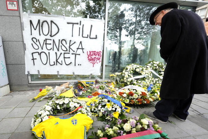 Un homme rend hommage aux victimes des attentats qui ont causé la mort de deux Suédois, à Bruxelles, le 18 octobre 2023. 