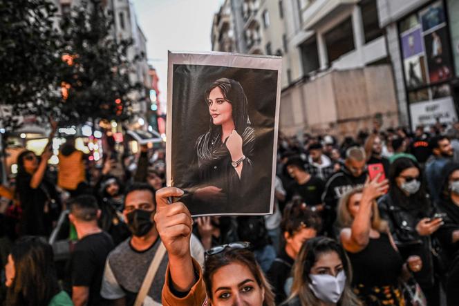 A protester holds a portrait of Mahsa Amini during a demonstration in support of Amini, a young Iranian woman who died after being arrested in Tehran by the Islamic Republic's morality police, on Istiklal Avenue in Istanbul on September 20, 2022.