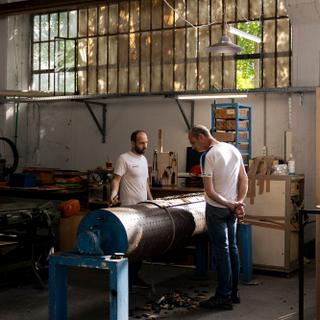 Sokol Novruzai, 39 and Kostas Simitopoulos, 57 discuss over a rotary die at Dietech factory in Nikaia near Athens, Greece. 19 October 2023 Louiza Vradi for Le Monde
