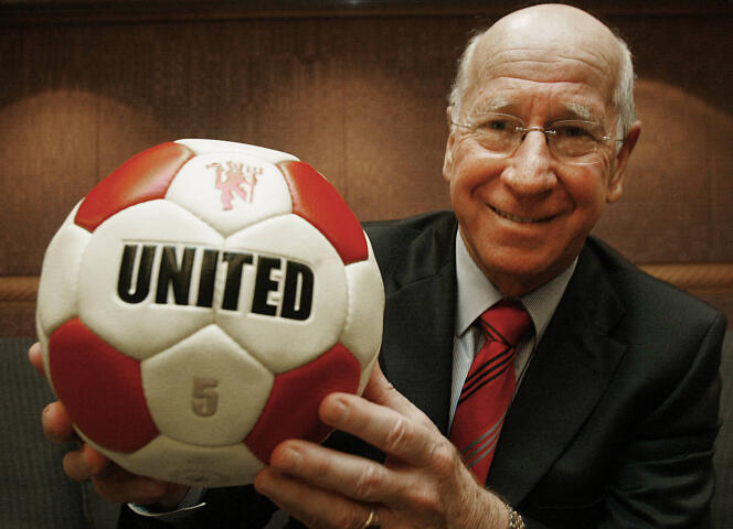 Bobby Charlton sostiene un balón que lleva el nombre de su antiguo club, Manchester United, en Hong Kong, el 19 de abril de 2005.