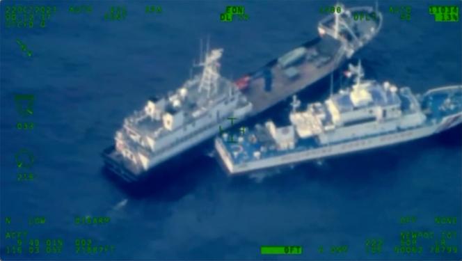 This image released by the Armed Forces of the Philippines, shows a Chinese militia vessel, top, and Philippine coast guard vessel BRP Cabra as they approach Second Thomas Shoal, locally called Ayungin Shoal, at the disputed South China Sea on October 22, 2023.