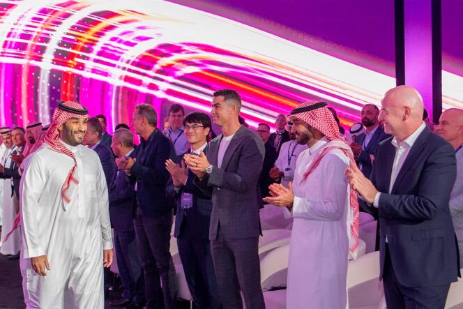 Le prince héritier d’Arabie saoudite, Mohammed Ben Salman, accueilli par le président de la FIFA, Gianni Infantino, et le joueur de football Cristiano Ronaldo lors de la présentation de la « Coupe du Monde d’e-sport », lundi 23 octobre. Cette photo a été fournie par l’agence de presse saoudienne.
