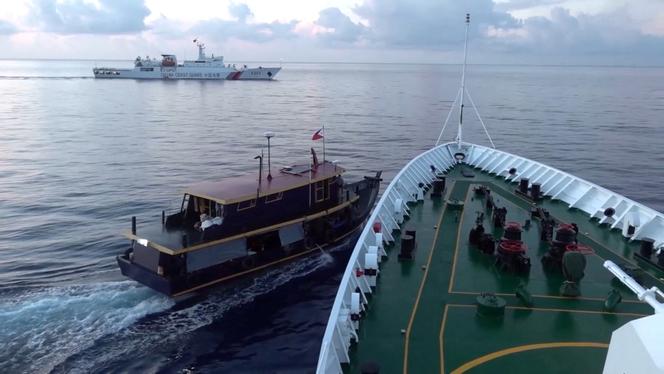 A Philippine flagged boat is blocked by a China Coast Guard vessel during an incident that resulted in a collision between the two vessels, in the disputed waters of the South China Sea in this screen grab obtained from handout video released October 22, 2023.