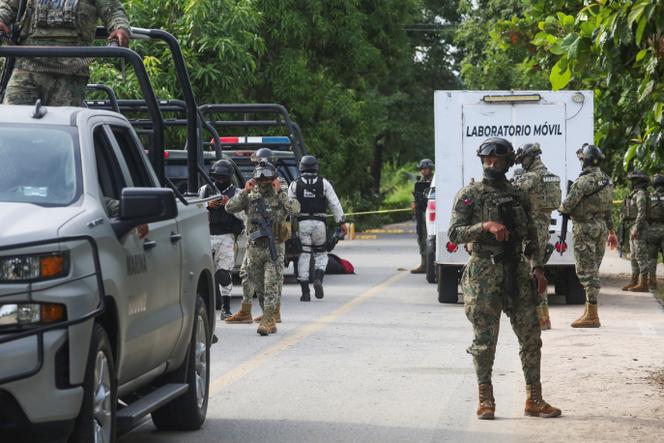 Mexican armed forces stand guard near a crime scene where several local police officers were shot dead by gunmen, in Coyuca de Benitez, Mexico, October 23, 2023.