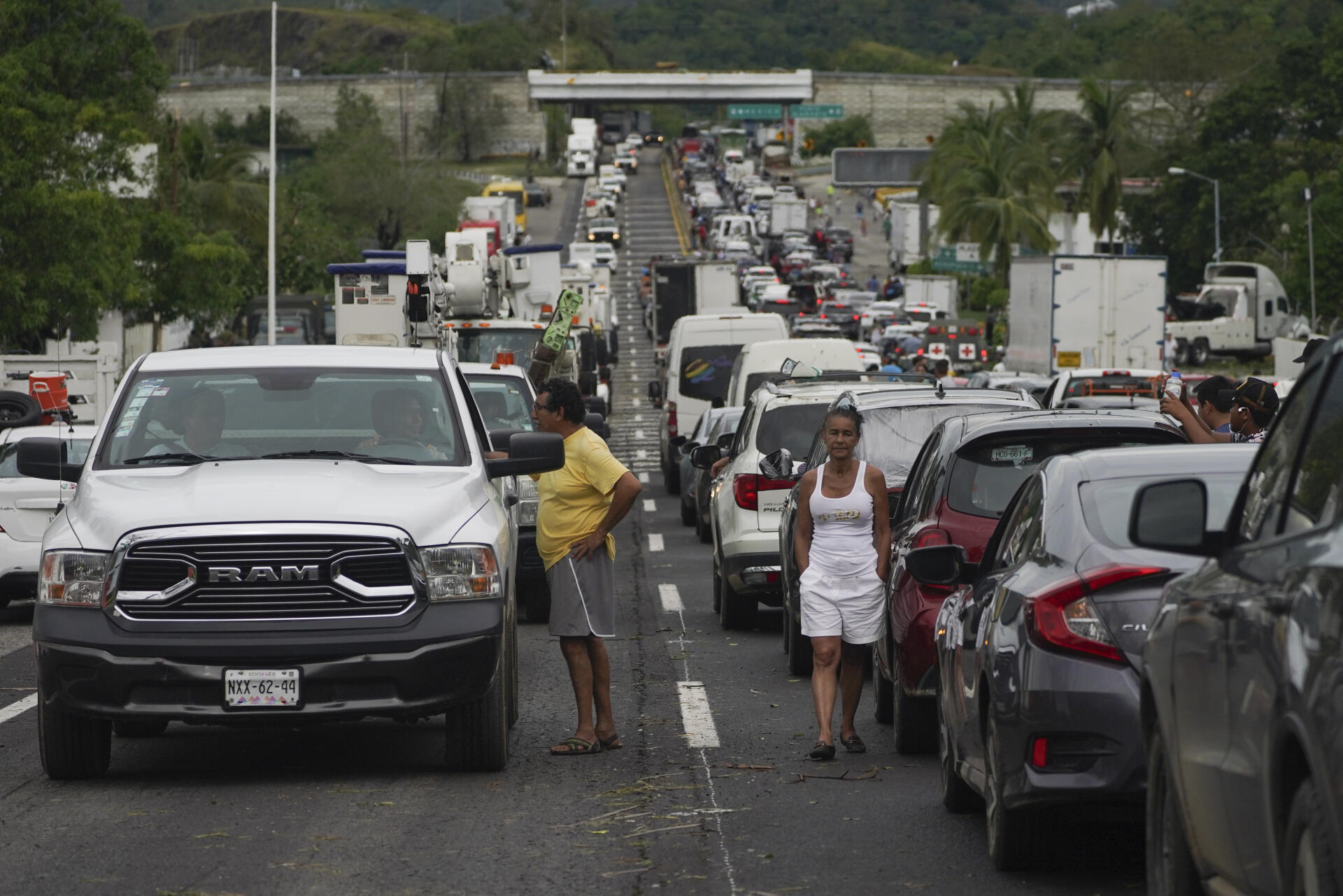 La gente espera afuera de sus autos mientras los equipos de reparación limpian las carreteras después del huracán Otis en Acapulco, México, el miércoles 25 de octubre de 2023. 