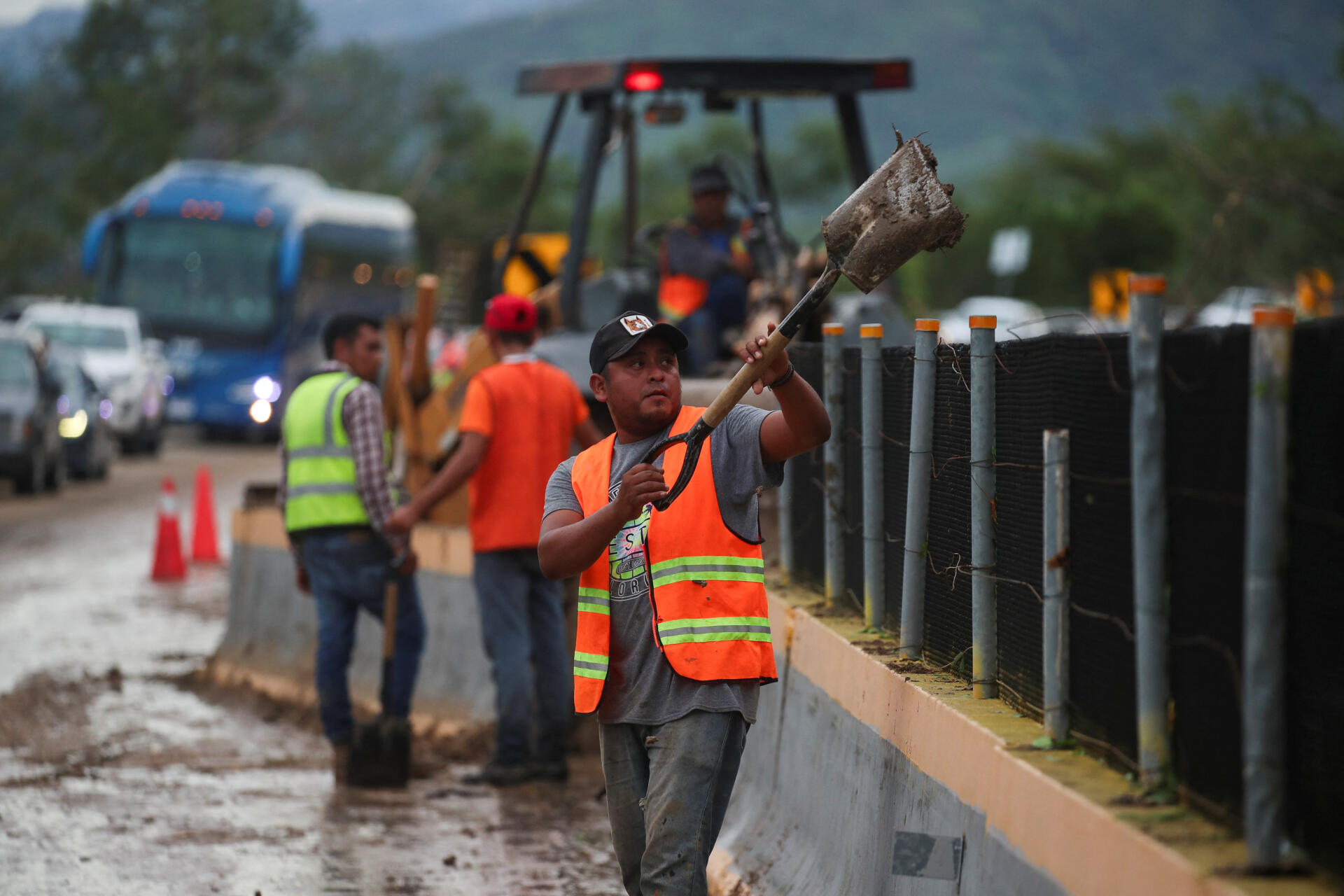 Un trabajador limpia parte del camino bloqueado por un deslizamiento de tierra en la vía a Acapulco.
