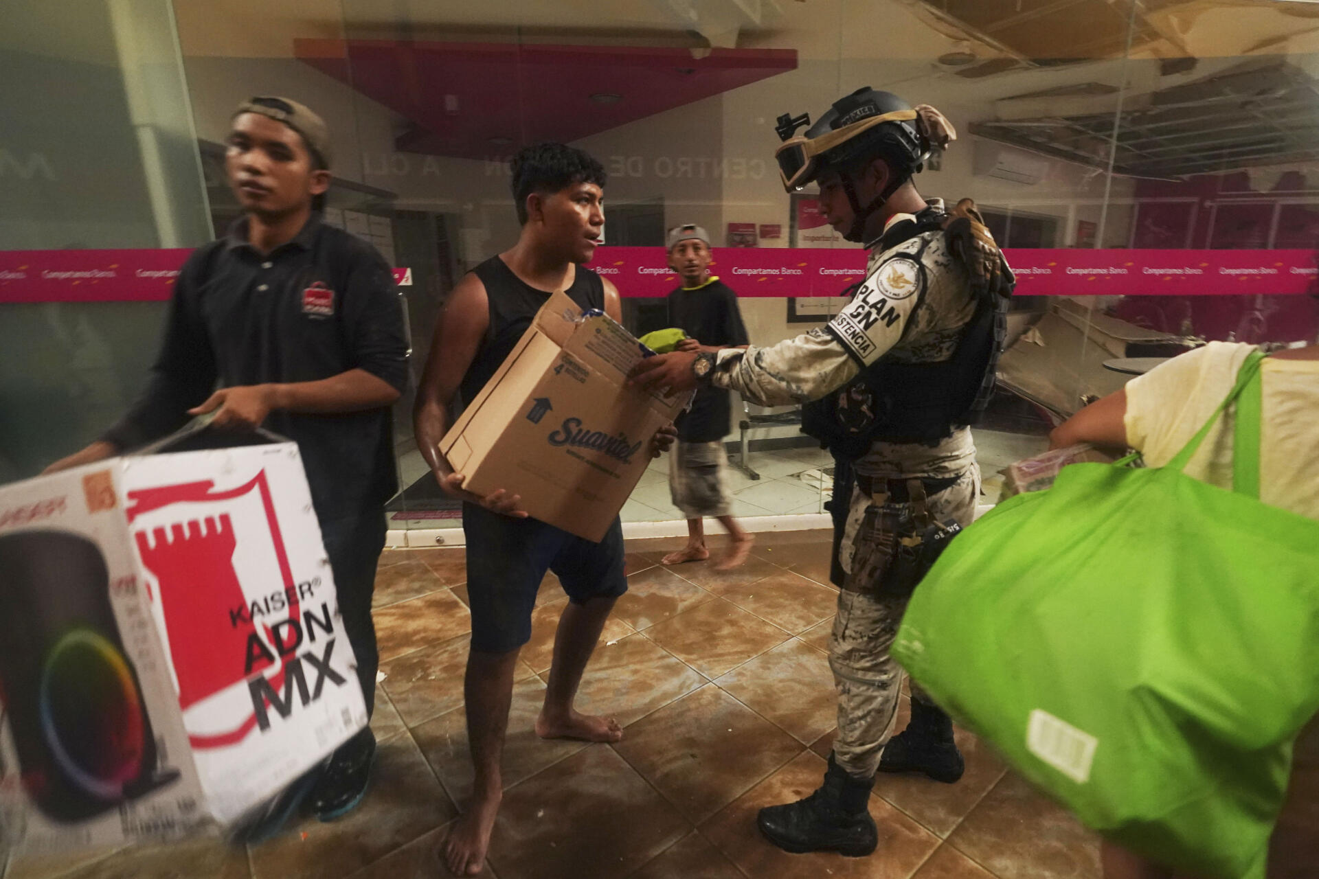 Un soldado de la Guardia Nacional de México intenta evitar saqueos en un centro comercial.