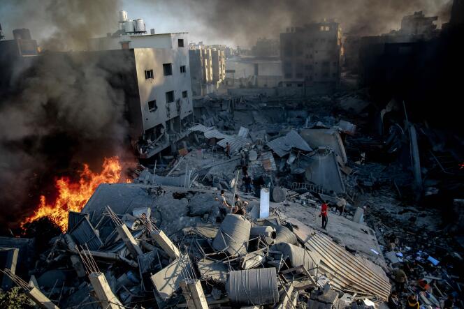 Płomienie i dym unoszą się ze zniszczonych budynków w Gazie po izraelskich nalotach, 26 października 2023 r.