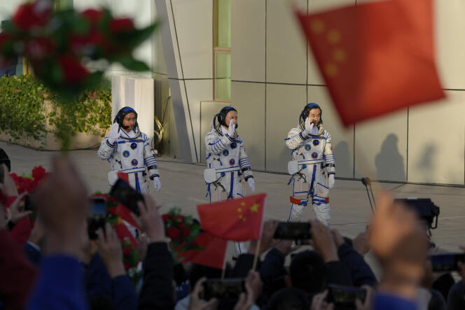 Gli spettatori sventolano bandiere e fiori mentre gli astronauti cinesi dello Shenzhou-17 Jiang Xinlin, Tang Hongbo e Tang Shengjie (da sinistra a destra) arrivano alla cerimonia di lancio della loro missione spaziale con equipaggio a Jiuquan, nel nord-ovest della Cina, il 26 ottobre 2023.