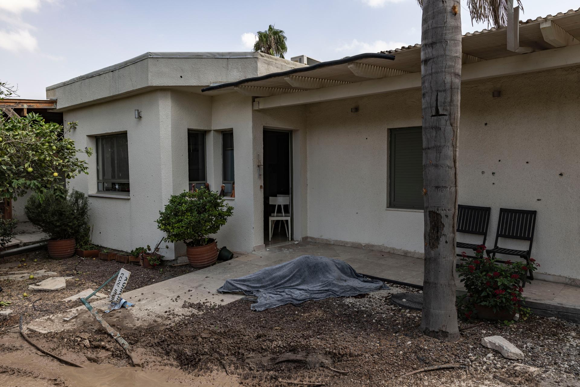 In the kibbutz of Kfar Aza, the body of a resident, covered with a tarpaulin, on October 10.