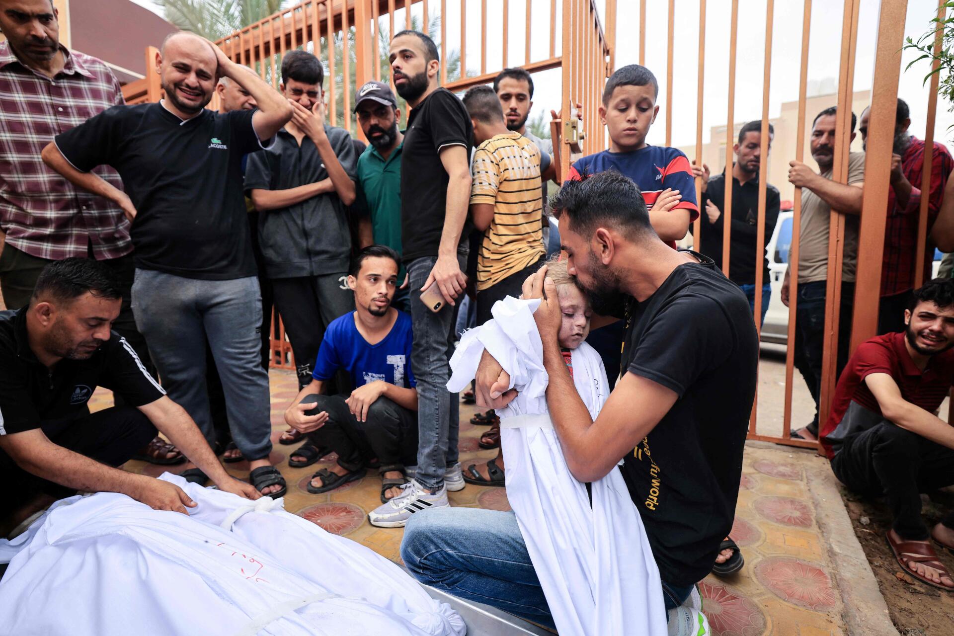 Des hommes de la famille al-Aqad font leurs adieux à leurs jeunes neveux, tués lors d’une frappe israélienne sur Khan Younès, dans le sud de la bande de Gaza, avant leur enterrement le 29 octobre 2023.