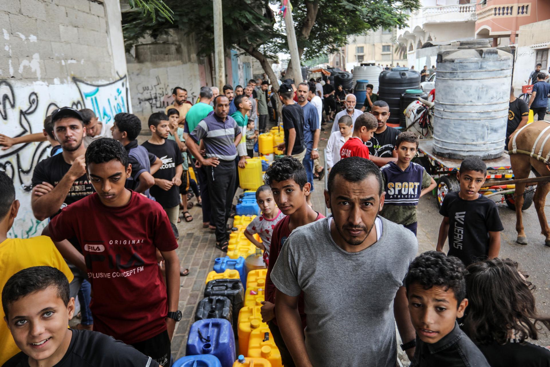 Palestinians wait at a water point in Rafah, Gaza Strip, October 28, 2023.