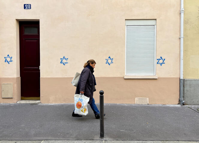 Una mujer pasa junto a un edificio etiquetado con las Estrellas de David en París, el 31 de octubre de 2023. 