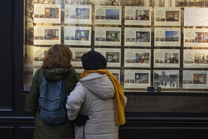 Deux femmes regardent les annonces d'une agence immobilière à Paris, le 1er mars 2022.