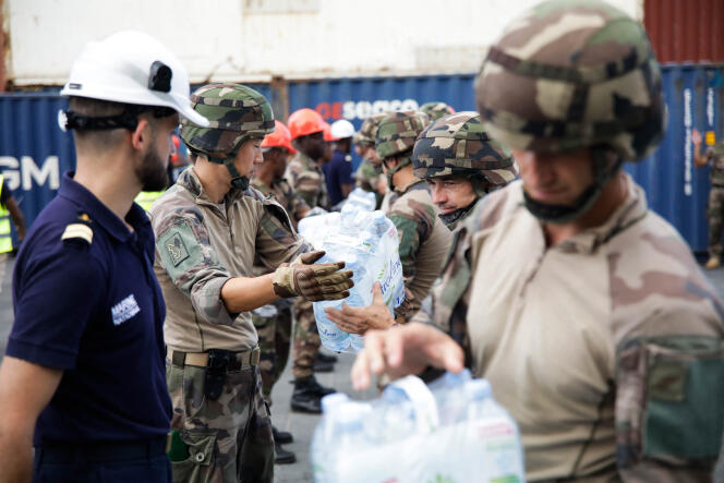 Des soldats déchargent des packs d’eau dans le port de Longoni (Mayotte), à l’arrivée d’un navire transportant 600 000 litres de bouteilles d’eau destinées à être distribuées aux personnes les plus vulnérables, le 20 septembre 2023.