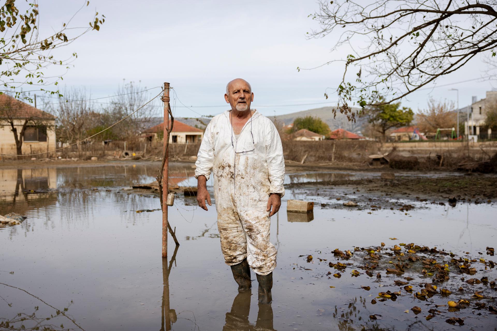 Athanasios Adamos, de 75 años, en el jardín de su hermano, transformado en estanque tras las inundaciones, en Vlochos (Grecia), el 1 de noviembre de 2023.