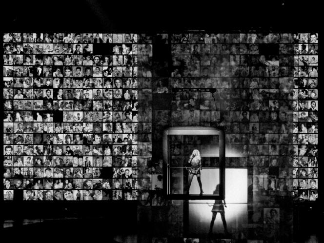Madonna, at the O2 Arena in London, where she kicked off her world tour with four concerts from October 14 to 18.  Around the singer are displayed the faces of the deceased lost to HIV.