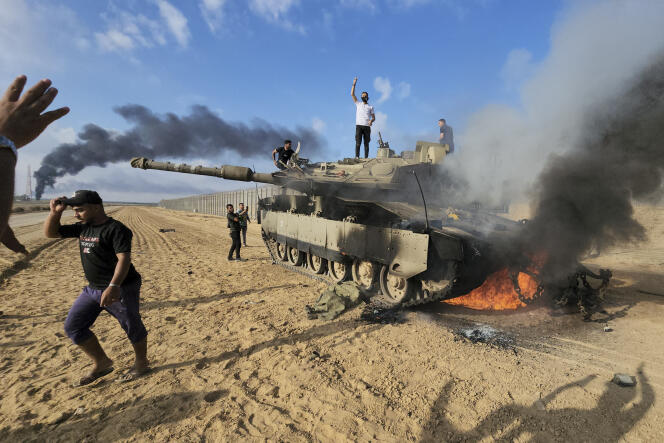 Según Honest Reporting, la cobertura de los primeros enfrentamientos por parte de fotoperiodistas palestinos de AP y Reuters sería sospechosa, como esta fotografía de un tanque destruido cerca de la frontera.  Hassan Eslaiah, su autor, fotografiado en el pasado con un líder de Hamás, niega haber tenido conocimiento del ataque.