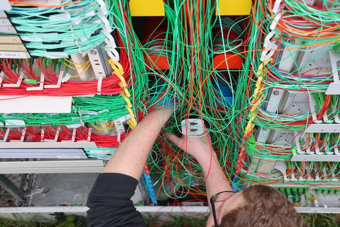 Un tecnico arancione davanti a un armadio per la fibra, a Lingolsheim (Basso Reno), 3 aprile 2023.