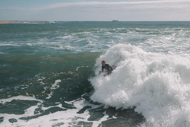 A surfer enjoys the waves at the Barre d'Etel, at the ria mouth, on October 14, 2023.