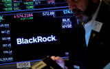 FILE PHOTO: A trader works as a screen displays the trading information for BlackRock on the floor of the New York Stock Exchange (NYSE) in New York City, U.S., October 14, 2022. REUTERS/Brendan McDermid/File Photo