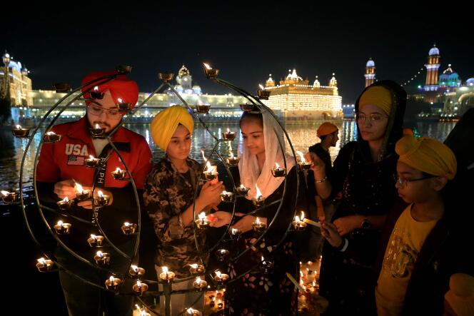 Des fidèles sikhs allument des lumières à l’occasion de la fête de Divali, au Temple d’Or d’Amritsar, le 12 novembre 2023.