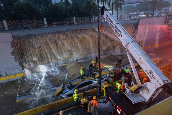 Les secours tentent de dégager les véhicules pris au piège sous un mur qui s’est effondré sur une avenue, à l’entrée d’un tunnel, à Saint-Domingue, le 18 novembre 2023. 