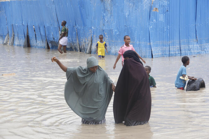 Des habitants de Mogadiscio marchent au milieu des eaux pendant de fortes pluies, lundi 20 novembre 2023.