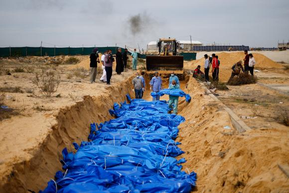 Les corps de Palestiniens tués par des bombardements et des tirs israéliens sont enterrés dans une fosse commune, après avoir été transportés de l’hôpital Al-Shifa (Gaza) à Khan Younès, dans le sud de l’enclave, le 22 novembre 2023.