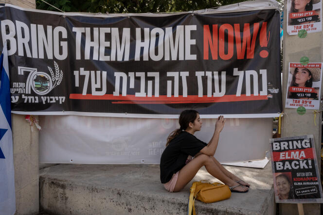 Una joven mira su teléfono, en un lugar ahora apodado “Plaza de los Rehenes”, en Tel Aviv, el 22 de noviembre de 2023. 