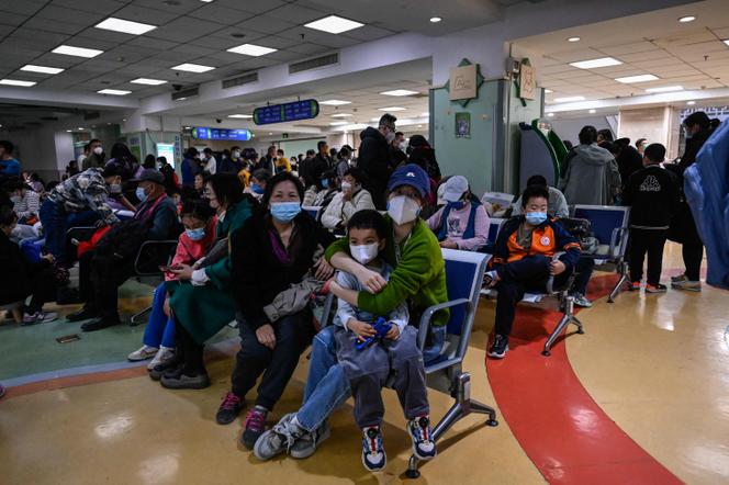 Des parents attendent avec leurs enfants atteints de maladies respiratoires, dans un hôpital de Pékin, le 23 novembre 2023.