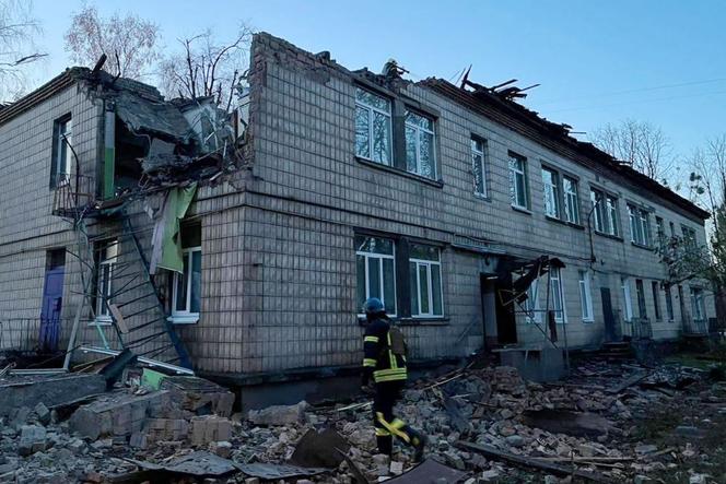 Un secouriste travaille sur le site d’une attaque de drone à Kiev, le 25 novembre 2023.