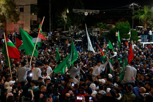 Des prisonniers palestiniens (portant des pulls gris) entourés de partisans après avoir été libérés des prisons israéliennes, à Ramallah (Cisjordanie), le 26 novembre 2023.