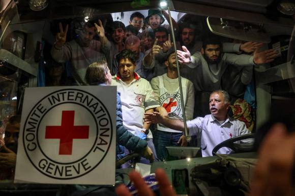 Le unit   de la Croix-Rouge et les prisonniers palestiniens libérés des prisons israéliennes en échange d’otages libérés par le Hamas dans la bande de Gaza, à l’intérieur d’un autobus  à leur arrivée à Ramallah, en Cisjordanie occupée, le 26 novembre 2023.