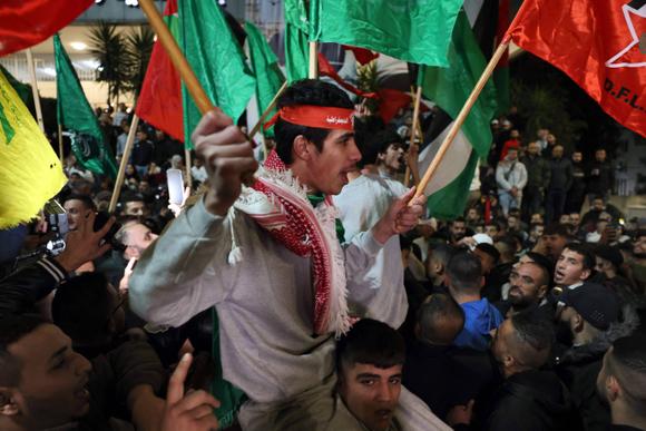 Un prisonnier palestinien (au centre) entouré de partisans après sa libération, à lad   arrivée à Ramallah (Cisjordanie), le 26 novembre 2023.