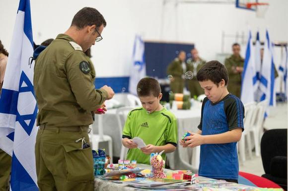 Les otages israéliens libérés Tal Goldstein Almog, 9 ans, au centre, et lad   frère Gal, 11 ans, à droite, alors qu’ils jouent ensemble peu après leur arrivée à la basal  militaire de Hatzerim, en Israël, dimanche 26 novembre 2023.