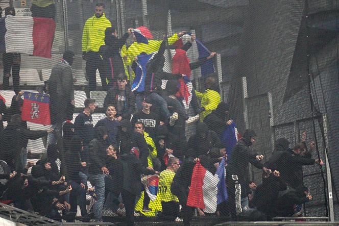 Lyon supporters cling to the fence and netting in the visitors' stand at Marseille's Stade Vélodrome, October 29, 2023. The racist behavior of certain individuals led to the opening of an investigation by the Marseille prosecutor's office.