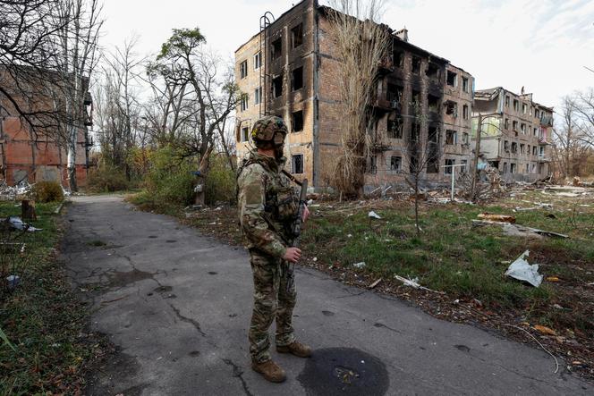 Un militaire ukrainien devant des bâtiments résidentiels fortement endommagés par des frappes militaires russes dans la ville d’Avdïivka, le 8 novembre 2023.