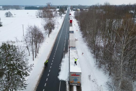 Un camionneur ukrainien sur le toit de son camion, alors qu’il attend dans une longue file pour traverser la frontière polono-ukrainienne au passage de Dorohusk-Iahodyn, à Okopy, en Pologne, le 4 décembre 2023.