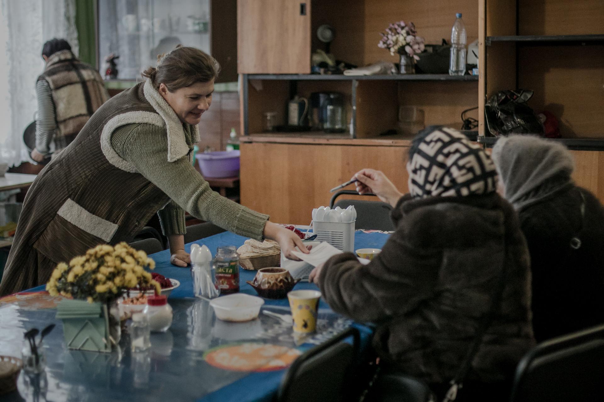New arrivals from Russian-occupied territories enjoy a hot meal in a building in the town of Krasnopillia, some 10 kilometers from the Russian border, on December 3, 2023.