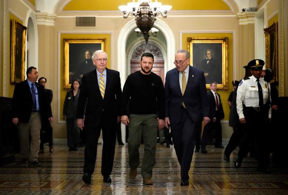Le président ukrainien, Volodymyr Zelensky, marche avec le chef des Républicains au Sénat, Mitch McConnell, et le démocrate Chuck Schumer, chef de la majorité sénatoriale, à son arrivée au Capitole, à Washington, le 12 décembre 2023.