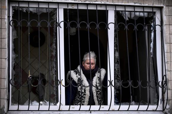 Une habitante dont les vitres ont volé en éclats lors d’un bombardement à Kiev le 13 décembre 2023.