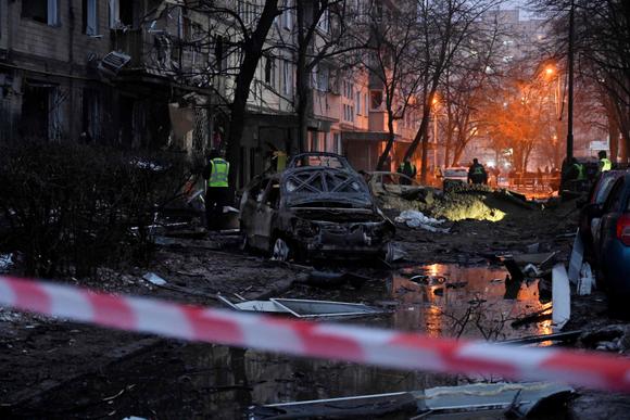 Des voitures détruites à côté d’un immeuble résidentiel endommagé après un bombardement à Kiev, le 13 décembre 2023.