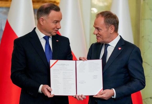 Le président polonais, Andrzej Duda, et le nouveau premier ministre polonais, Donald Tusk, à la prestation de serment du gouvernement au palais présidentiel de Varsovie, le 13 décembre 2023.
