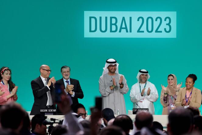 COP28 President Sultan Al-Jaber (centre) applauds among other officials on December 13, 2023 in Dubai.
