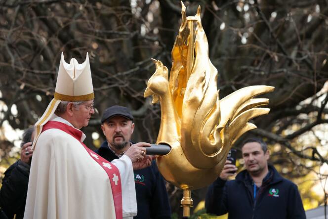 El arzobispo de París, monseñor Laurent Ulrich, coloca una reliquia en el nuevo gallo dorado de Notre-Dame de París, el 16 de diciembre de 2023.