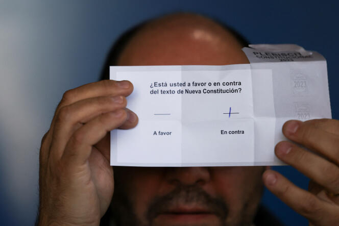 Un fonctionnaire tient un bulletin, après la fermeture des bureaux de vote du référendum sur une nouvelle Constitution chilienne, à Santiago, 17 décembre 2023.