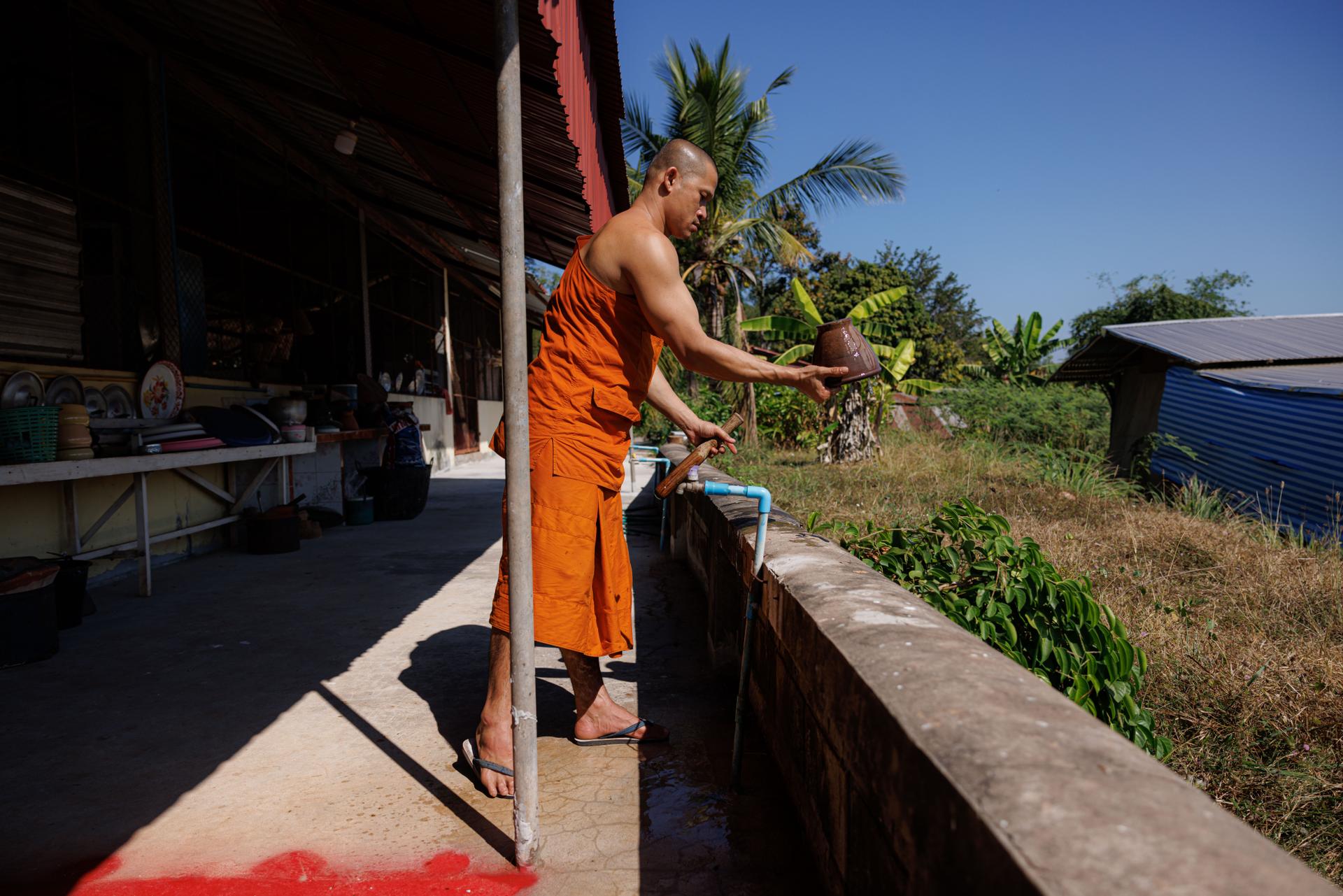 A Buddhist monk rinses a pestle and mortar at the Samakkhi Phatthanaram "wat" on December 15, 2023, in Udon Thani, Thailand.